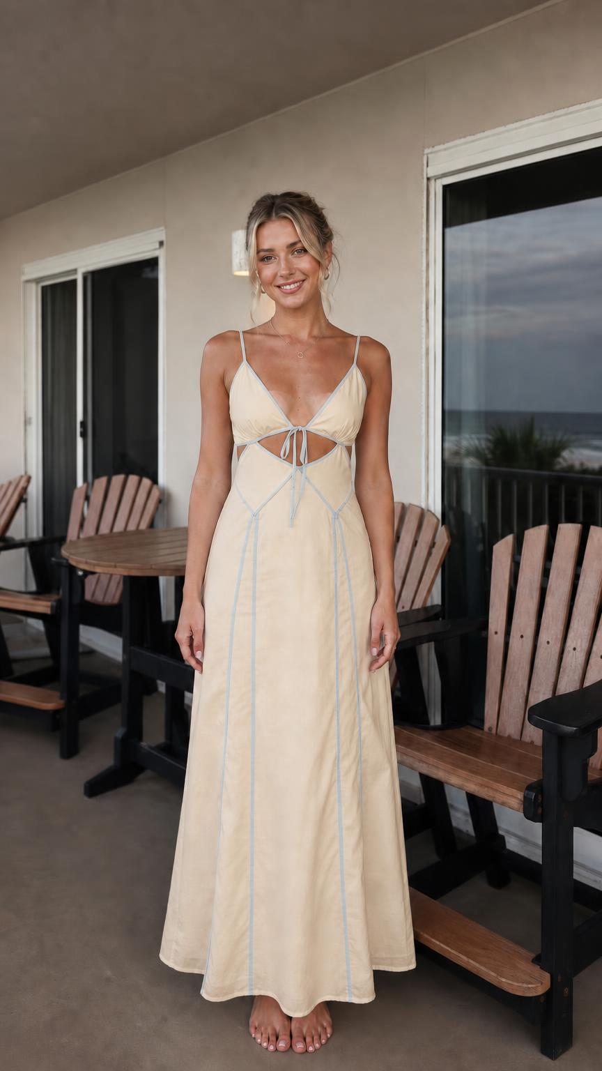 Front view of woman wearing beige maxi dress with blue contrast piping