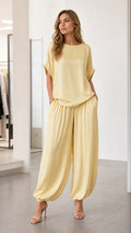 Front view of model wearing yellow two-piece lounge set with harem pants