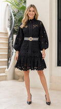 Front view of woman wearing black lace mini dress with striped belt