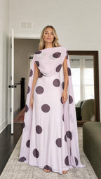 Model wearing lavender polka dot cape maxi dress from the front