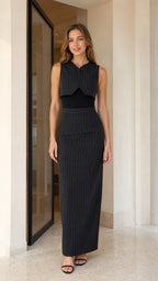 Front view of model wearing black pinstripe vest and maxi skirt set