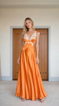 Front view of model wearing orange satin maxi dress with white lace