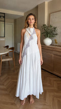 Front view of woman wearing white halter maxi dress