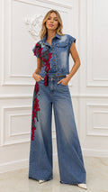 Front view of model wearing blue embroidered denim vest and wide-leg pants set
