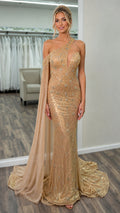 Front view of gold one-shoulder beaded evening dress with cape