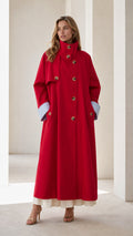 Front view of woman wearing a long red trench coat with contrast cuffs
