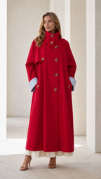 Front view of woman wearing a long red trench coat with contrast cuffs