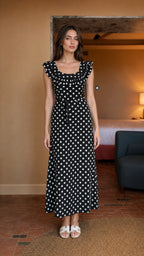 Front view of woman wearing black polka dot midi dress