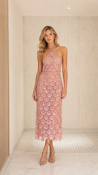 Front view of model wearing blush pink sequin halter midi dress