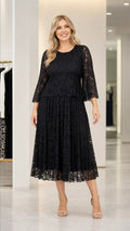 Front view of woman wearing black lace midi dress