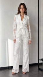Front view of woman wearing white lace blazer and wide-leg pants set