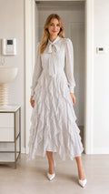 Front view of model wearing white polka dot midi dress with tie neck