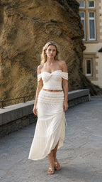 Woman wearing ivory off-shoulder crop top and tiered maxi skirt set outdoors
