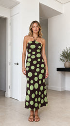 Model wearing brown polka dot halter midi dress, front view
