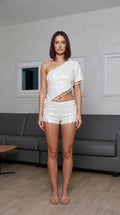 Model wearing white one-shoulder sequin crop top and shorts set, front view