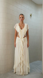 Front view of model wearing ivory ruffled two-piece maxi set