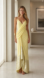 Front view of woman wearing yellow draped sequin maxi dress