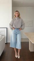 Model wearing white plaid high-neck blouse with light denim culottes from the front