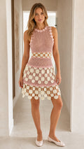 Front view of woman wearing pink crochet mini dress