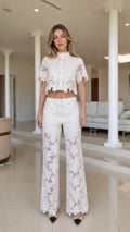 Front view of woman wearing white lace crop top and wide leg pants set