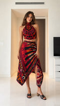 Woman wearing red geometric print halter crop top and asymmetric midi skirt set front view