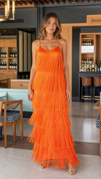 Front view of model wearing vibrant orange tiered fringe maxi slip dress