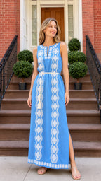 Front view of woman wearing blue embroidered sleeveless maxi dress on brick steps