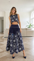 Model wearing navy embroidered floral crop top and maxi skirt set
