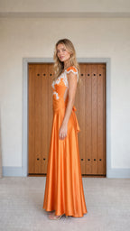 Side profile view of orange satin lace-trim evening gown