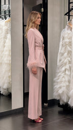Model wearing pink satin feather cuff pantsuit side profile