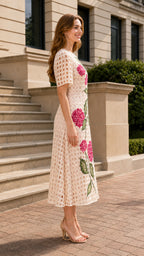 Side profile of woman in beige floral embroidered midi dress
