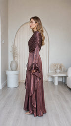 Side profile of model in metallic brown pleated maxi dress