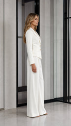 Side profile of woman in white pant suit showing structured blazer and high-waist trousers