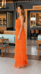 Side profile of model in orange fringe maxi dress