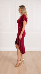 Side profile view of burgundy midi dress showing high-low hem