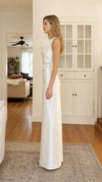 Side profile of model in white satin maxi dress