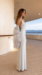 Side profile of model in silver satin dress and feather shrug