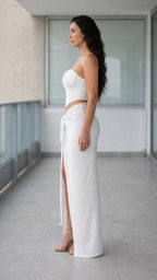 Side profile view of woman wearing white two-piece corset and skirt set