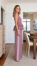 Side view of model highlighting peplum detail and striped trousers