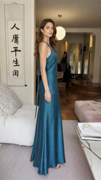 Side view of model in teal satin maxi dress