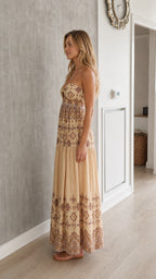 Side profile of model in beige printed maxi dress