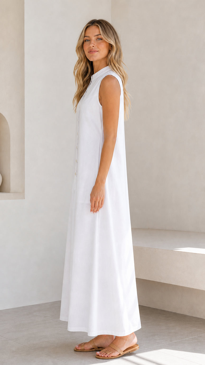 Side profile view of a woman wearing a white sleeveless maxi dress