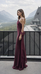 Side profile view of burgundy satin evening gown outdoors