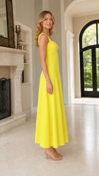 Side view of woman wearing yellow tie-front midi dress