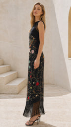 Side profile view of black embroidered fringe maxi dress