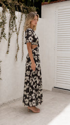 Side view of model wearing black floral cutout maxi dress