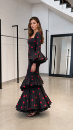 Side profile view of black and red polka dot maxi dress with ruffle sleeves