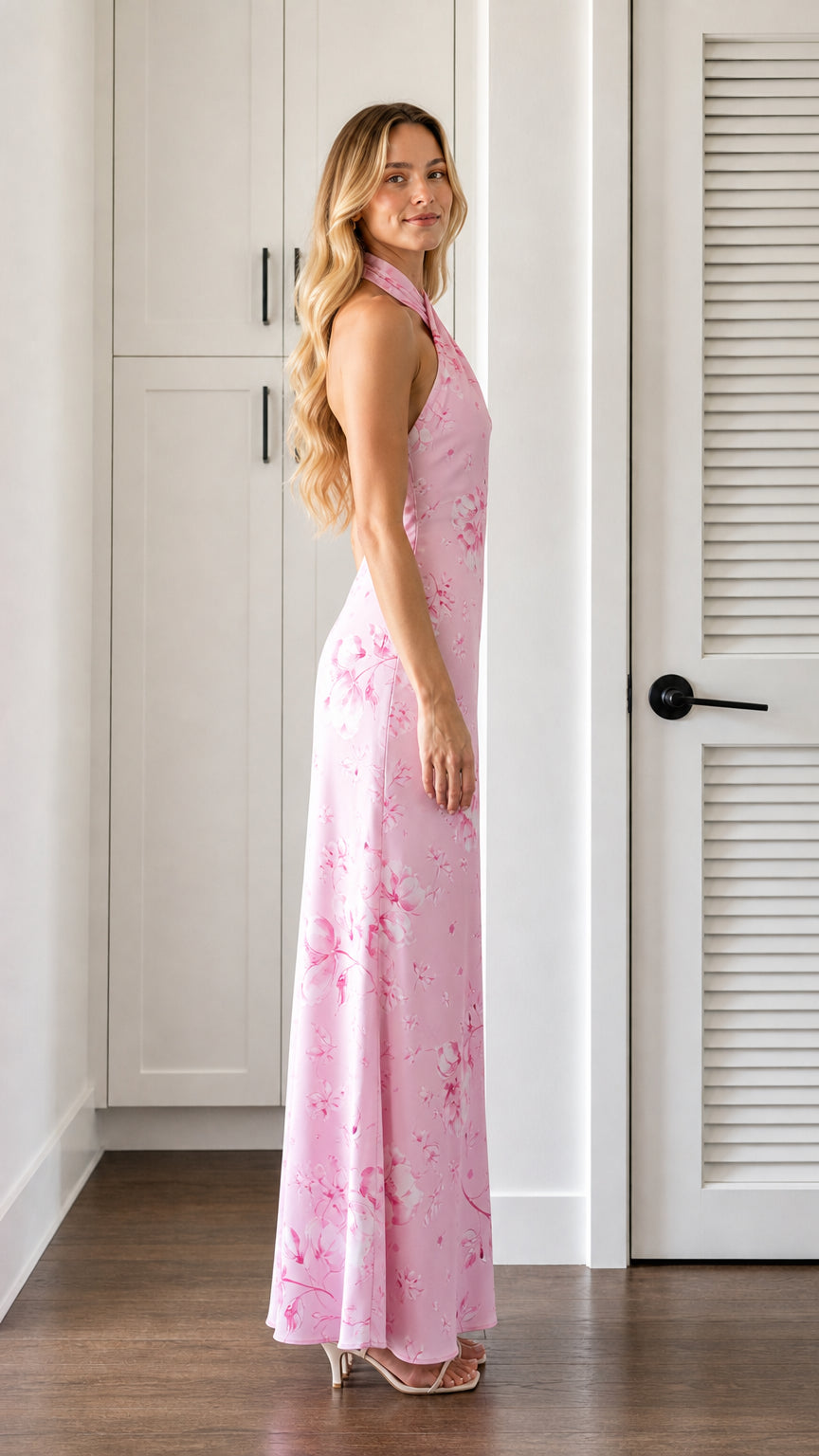 Side profile of model wearing pink floral halter neck maxi dress