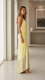 Side profile view of yellow draped sequin maxi dress