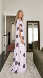 Side profile of model in lavender polka dot cape maxi dress